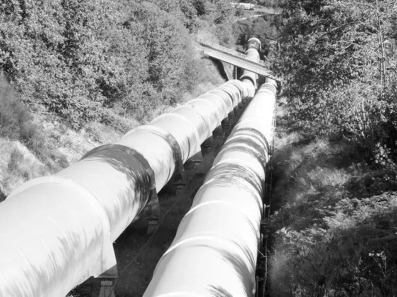 Dos tuberías de gran diámetro bajando en paralelo por la ladera de un valle